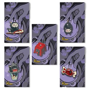 May include: A collection of five enamel pins featuring cartoonish characters. The pins include a character on a skateboard, a bat, a character on a red stool, a character in a cup, and a piece of candy. Each pin is set against a purple background.