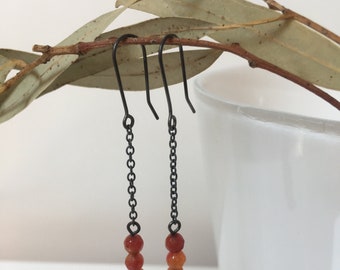 Long red agate dangle earrings on oxidized sterling silver hooks and chain. Chandelier earrings with tiny red agates