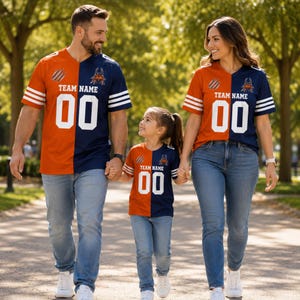 May include: Three matching short-sleeve jerseys featuring a split design of orange on the left and navy blue on the right. Each jersey displays the text TEAM NAME, the number 00 in white, three white stripes on the sleeves, and a small graphic logo.