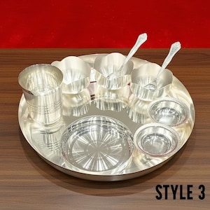 May include: A silver-colored dinner set consisting of a large round tray, a tall tumbler with horizontal ridges, two small bowls with scalloped edges, two small plain bowls, and two spoons. The text STYLE 3 is visible in the bottom right corner.