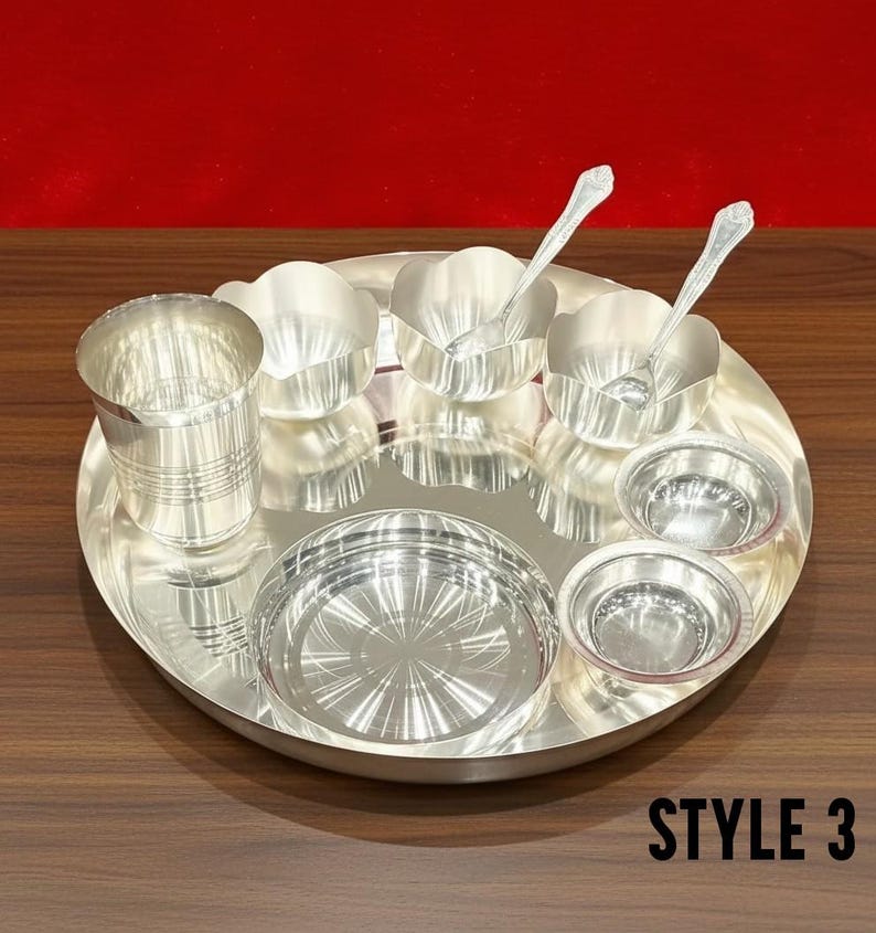 May include: A silver-colored dinner set consisting of a large round tray, a tall tumbler with horizontal ridges, two small bowls with scalloped edges, two small plain bowls, and two spoons. The text STYLE 3 is visible in the bottom right corner.