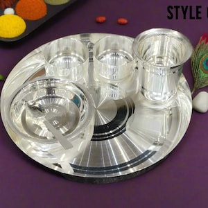 May include: A shiny silver-toned dinnerware set consisting of a large round plate, two small bowls, a larger bowl with a matching spoon, and a tall drinking glass. The text "STYLE 6" is printed in the upper right corner of the image.