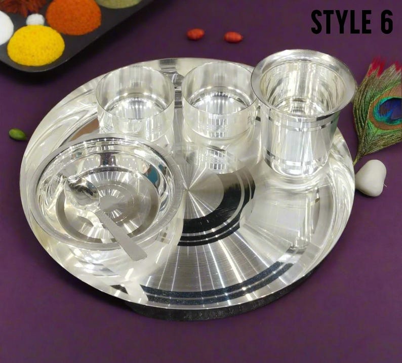 May include: A shiny silver-toned dinnerware set consisting of a large round plate, two small bowls, a larger bowl with a matching spoon, and a tall drinking glass. The text "STYLE 6" is printed in the upper right corner of the image.