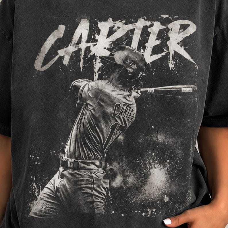 May include: Black t-shirt with a grayscale image of a baseball player in action. The name "CARTER" is printed in white above the player, and the player's jersey shows "CARTER" and the number "17".