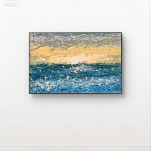 Puede incluir: Pintura abstracta de paisaje marino con marco negro. La obra presenta una representación texturizada del océano con tonos azules y blancos, contrastados por un cielo amarillo y gris. La pintura está montada en una pared blanca.
