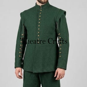 May include: A dark green jacket featuring a high mandarin collar, a front vertical row of small brass-toned buttons, and matching brass-toned buttons along the outer seam of each long sleeve. The text Theatre Crafts is visible.