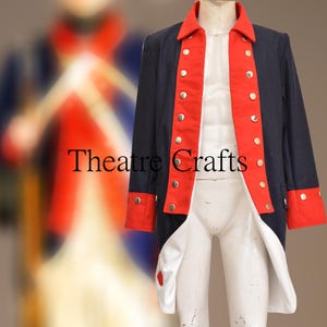 Puede incluir: Una chaqueta teatral azul marino y roja con botones dorados. La chaqueta tiene ribetes rojos en el cuello, la parte delantera y los puños. El texto "Theatre Crafts" es visible en la parte delantera de la chaqueta.