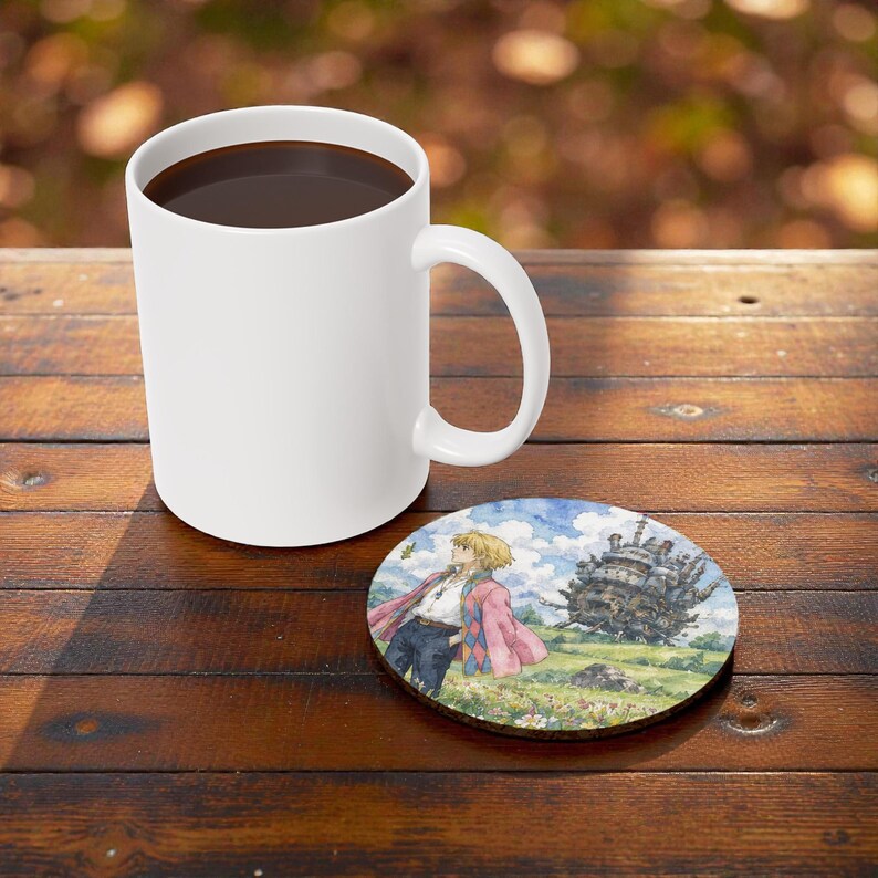 Pu&ograve; includere: Una tazza da caff&egrave; in ceramica bianca piena di liquido scuro &egrave; appoggiata su una superficie di legno accanto a un sottobicchiere rotondo. Il sottobicchiere presenta un'illustrazione ad acquerello di un personaggio con un cappotto rosa e un grande edificio.