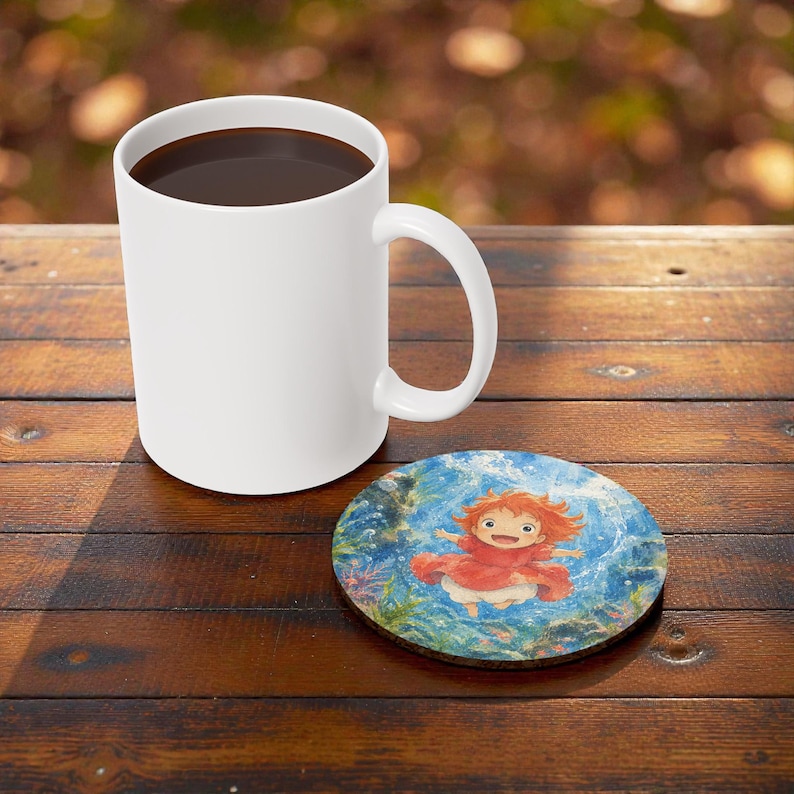 May include: A white ceramic coffee mug filled with dark liquid sits on a wooden table next to a round coaster. The coaster features a colorful illustration of a character in a red dress and orange hair.