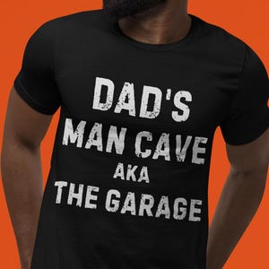 面白い、ダッドズ・マン・ケイブ（ガレージの格言）Tシャツ。レース、車の修理、メカニック、便利屋が好きなお父さんへのギフト
