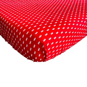 May include: Red fitted crib sheet with a white crown pattern.