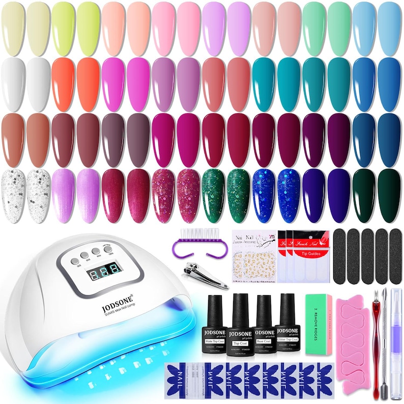 K&ouml;nnte beinhalten: Ein Nagelkunst-Set mit einer Vielzahl von Gel-Nagellackfarben, einer UV-LED-Nagellampe und Nagelkunstwerkzeugen. Die Gel-Nagellackfarben umfassen Farbt&ouml;ne von Rosa, Blau, Gr&uuml;n und neutralen T&ouml;nen. Das Set enth&auml;lt Nagelfeilen, Nagelaufkleber sowie Deck- und Basislack.