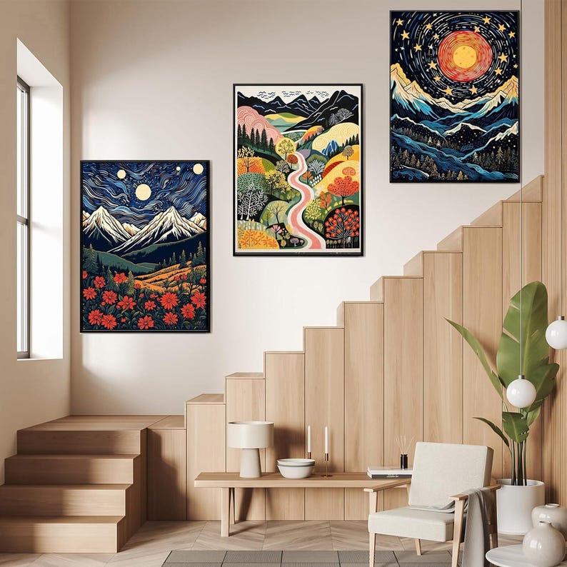 May include: Three framed landscape art prints. One depicts a mountain scene with a full moon and red flowers. Another shows a winding pink river through colorful trees. The third features a starry night sky over mountains.