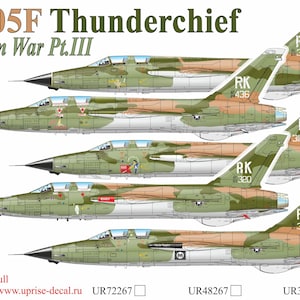 May include: An illustration of several F-105F Thunderchief fighter jets in a camouflage pattern. The image includes text that reads "F-105F Thunderchief Vietnam War Pt.III". The jets are green, brown, and tan.