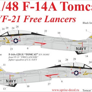 May include: A detailed illustration of a 1/48 F-14A Tomcat fighter jet, featuring the VF-21 Free Lancers squadron markings. The design includes the number 205, a navy star, and the word "NAVY". The image is predominantly gray with red and yellow accents.