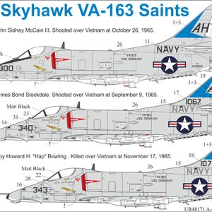 Puede incluir: Diagrama de tres aviones A-4E Skyhawk, cada uno con diferentes números de serie y marcas. Los aviones son de color gris claro con detalles en azul y blanco. El texto "A-4E Skyhawk VA-163 Saints" está en la parte superior. Cada avión tiene la palabra "NAVY" y un emblema de estrella.