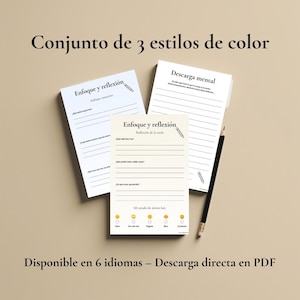 Puede incluir: Tres blocs de notas con texto en español, incluyendo "Enfoque y reflexión" y "Descarga mental". Los blocs de notas tienen páginas rayadas y preguntas para la reflexión. También hay un lápiz negro. El texto "Conjunto de 3 estilos de color" y "Disponible en 6 idiomas - Descarga directa en PDF" también es visible.