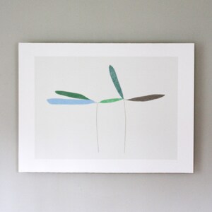 May include: A framed abstract art print featuring five stylized leaves in shades of blue, green, and brown. The leaves are arranged in a symmetrical pattern, with two leaves extending to the left and right, and one leaf extending upwards.