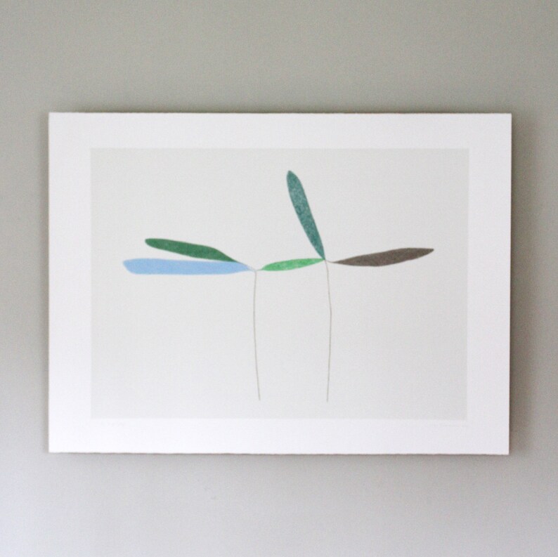 May include: A framed abstract art print featuring five stylized leaves in shades of blue, green, and brown. The leaves are arranged in a symmetrical pattern, with two leaves extending to the left and right, and one leaf extending upwards.