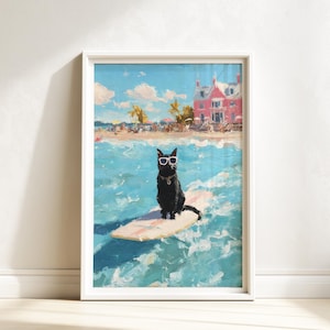 May include: Framed art print depicting a black cat wearing sunglasses, surfing on a light pink surfboard in the ocean. The background shows a beach scene with a pink building and palm trees under a blue sky.