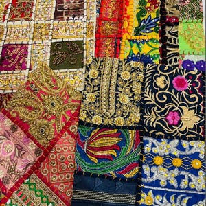 Puede incluir: Textil de patchwork colorido con intrincados bordados y abalorios. El diseño presenta cuadrados y rectángulos en varios colores, incluyendo rojo, dorado, azul y verde. El textil tiene una estética bohemia o étnica.