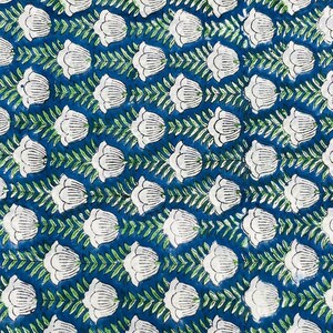 May include: A close-up of a fabric with a repeating floral pattern. White tulip-like flowers are arranged in rows against a deep blue background. Green leafy vines connect the flowers, creating a symmetrical design. The fabric has a textured appearance.