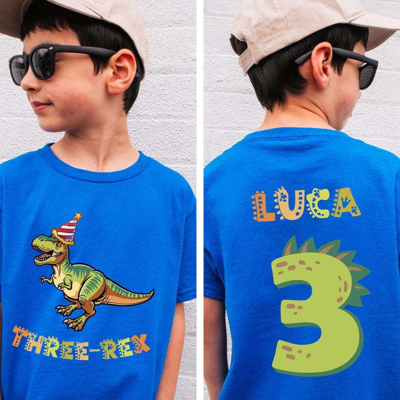 A boy wearing a blue t-shirt with a dinosaur and the text "Three-Rex" printed on it.