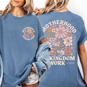 two women wearing blue t-shirts with a floral design and text on the back.