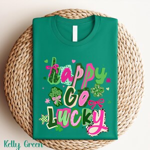 A green t-shirt with the text "Happy Go Lucky" printed on it, surrounded by various colorful and whimsical elements such as hearts, flowers, and shamrocks.