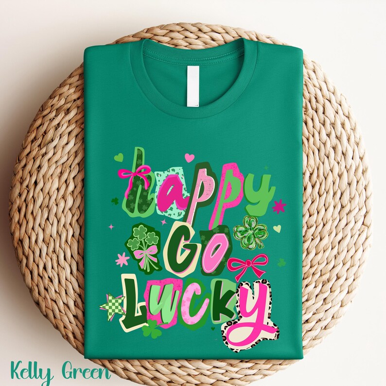 A green t-shirt with the text "Happy Go Lucky" printed on it, surrounded by various colorful and whimsical elements such as hearts, flowers, and shamrocks.