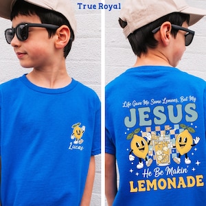 Personalized Jesus Lemonade Shirt with happy lemon graphics and the quote “Life Gave Me Some Lemons, But My Jesus He Be Makin’ Lemonade” — cute faith based kids sweatshirt and Christian shirt.