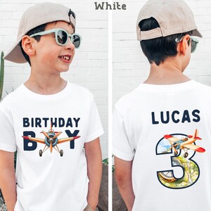 A boy wearing a white t-shirt with a graphic of an airplane and the text "Birthday Boy" printed on it.