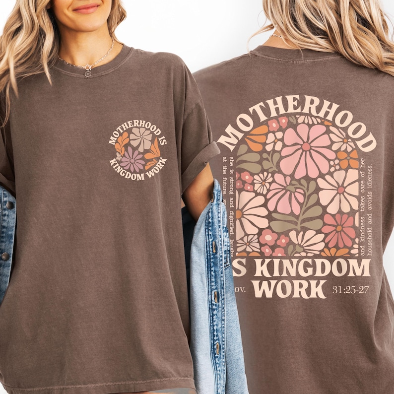 a woman wearing a brown t-shirt with a floral design and text printed on the back.
