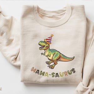 Dinosaur-themed family birthday shirts including a Three Rex or Four Rex kids tee with name and age on back, plus matching Mama Saurus, Dada Saurus, and sibling designs — ideal for dinosaur birthday parties.