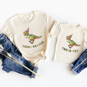 Dinosaur-themed family birthday shirts including a Three Rex or Four Rex kids tee with name and age on back, plus matching Mama Saurus, Dada Saurus, and sibling designs — ideal for dinosaur birthday parties.