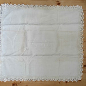 May include: White linen tablecloth with a crocheted border and embroidered initials "E.H."