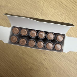 May include: A white cardboard box containing twelve cylindrical tubes arranged in two rows of six. Each tube features a light brown cap with the number 639 printed in a dark brown font on the top surface of the cap.