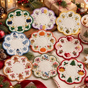 Puede incluir: Un conjunto de nueve posavasos circulares con bordes festoneados que presentan bordados estacionales como motivos de San Patricio, Pascua, abejas, muñecos de nieve, calabazas, corazones, pan de jengibre, aves y árboles de Navidad.