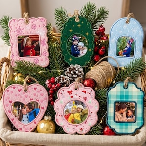 May include: Six decorative felt photo ornaments in various shapes including rectangular, oval, heart, and scalloped designs. Each ornament features a unique holiday-themed pattern and a central window displaying a personal photograph, suspended by twine.
