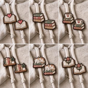 Puede incluir: Una colección de seis pares de parches bordados con diversos diseños, incluyendo libros abiertos con corazones, pilas de libros, tazas de café sobre libros, estanterías con plantas, gatos durmiendo sobre libros y libros abiertos con flores.