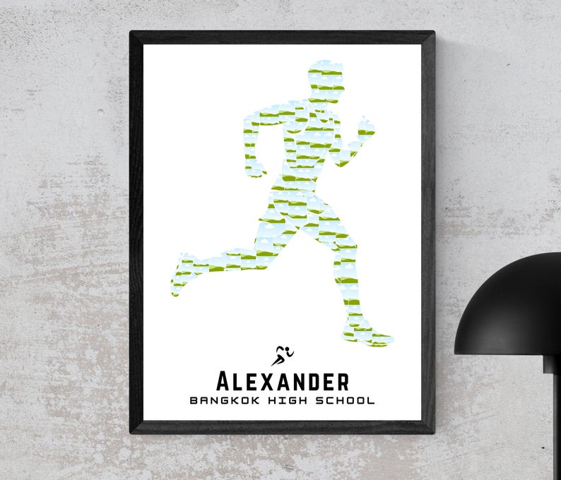 May include: Framed print featuring a running figure composed of green and blue brushstrokes on a white background. The name "ALEXANDER" and "BANGKOK HIGH SCHOOL" are printed in black below the runner silhouette. The frame is black.