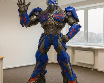 Könnte beinhalten: Lebensgroße Roboterstatue in Blau und Grau mit roten Akzenten. Die Figur steht in einer Grußgeste in einem Büro. Die detaillierte Statue ist ein Blickfang.