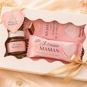 Peut inclure: Un coffret cadeau blanc avec une étiquette en forme de cœur portant l'inscription « Bonne fête Maman ». Il contient un pot et des bonbons roses avec l'inscription « Je t'aime Maman ». Le coffret est noué avec un ruban doré et entouré de roses roses.