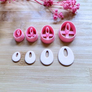Peut inclure: Ensemble de découpoirs à boucles d'oreilles en pâte polymère rose et boucles d'oreilles en argile assorties de différentes tailles. Les découpoirs sont ovales avec une fente verticale. Les boucles d'oreilles sont roses claires et ovales avec une fente verticale.