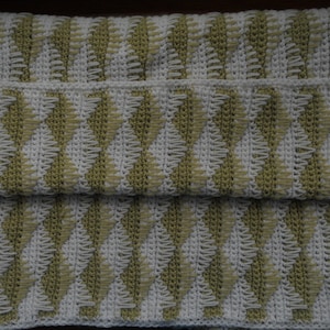 May include: A crocheted blanket with a chevron pattern in white and green.