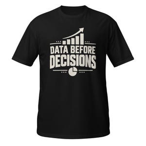 May include: A black short-sleeved t-shirt featuring a white graphic print on the chest. The design includes a bar chart with an upward-pointing arrow, the text "DATA BEFORE DECISIONS" in bold capital letters, and a circular pie chart icon below.