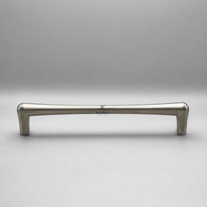 Op de afbeelding: Een geborsteld nikkel kastgreep met een zacht gebogen ontwerp. De handgreep heeft een gladde, afgeronde grip en rechthoekige montagepalen. Het woord "KULPERA" staat op de handgreep.