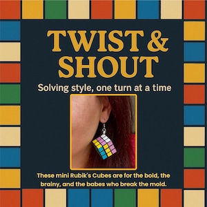 May include: A close-up of a Rubik's Cube earring. The earring is a miniature version of the classic puzzle, with colourful squares of blue, green, yellow, pink, and white. The image includes the text "TWIST & SHOUT" and "Solving style, one turn at a time."