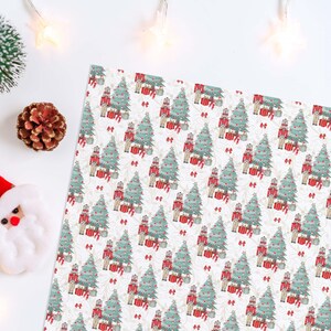 Puede incluir: Papel de regalo con temática navideña con un patrón repetido de árboles de Navidad, cascanueces y regalos envueltos en rojo, verde y blanco. También se ve una figura de Papá Noel, una piña y un pequeño árbol de Navidad.