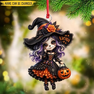 May include: A hanging ornament featuring a character with purple hair wearing a black witch hat adorned with an orange rose and a black dress with orange ruffles. The character holds a jack-o'-lantern bucket and has the name Elora printed on the hat.